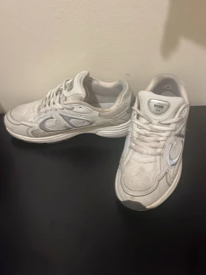 sneakers - Snygga vita sneakers med stora. Skorna har en chunky sula, mesh och läderpaneler samt svarta detaljer på sulan. Perfekta för dig som gillar exklusiv streetstyle och vill sticka ut med en lyxig touch.