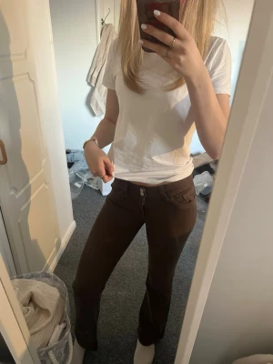 Bruna bootcut jeans från Nelly (34 short) - Säljer ett par bruna bootcut jeans från Nelly med klassiska fickor och kontrastsömmar.💕 Helt nya utan användning. Köpte dem för 700kr💓💓