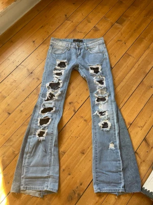 Lågmidjade jeans med spets slitningar - Säljer dessa så snygga och unika jeans som har insytt spetstyg under slitningarna. Jeansen är även omsydda till bootcut. Säljer jeansen då de tyvärr är försmå för mig runt låren och därför har jag tyvärr ingen bild med de på. Midjemått 37 cm, lårbredd 21,5 cm och innerbenslängd 80 cm💞💞