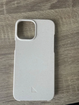 Beige mobilskal i växtbaserat material - Säljer ett stilrent beige mobilskal från a good company, till iPhone 12 Pro Max. Skalet är tillverkat i växtbaserat material och har en minimalistisk design med rundade hörn och stor kamerautskärning. Perfekt för dig som vill undvika plast och gillar hållbara val.