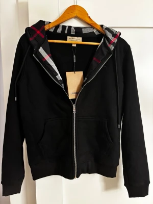 Burberry hoodie - Helt ny, oanvänd. Endast 900kr. (Pris kan diskuteras vid snabb affär, tveka ej på att buda) Storlek: M men passar S. 