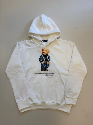 Vit Ralph lauren polo bear hoodie S - Vit Ralph Lauren Polo bear hoodie //  Mycket bra skick aldrig använd //  Storlek S //  Mått  Längd 63 Axelbredd 45cm  Bredd mellan armhålorna 50cm  Armlängd 58cm  Skriv vid minsta fråga eller fundering🤝