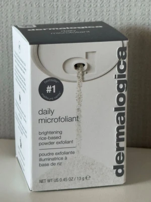Dermalogica Daily Microfoliant 13g - Pulverbaserad exfoliering från Dermalogica som ljusar upp huden. Innehåller risextrakt, salicylsyra och grapefruktolja. Kommer i en vit och grå åförpackning. Perfekt för daglig användning för en fräschare hud.