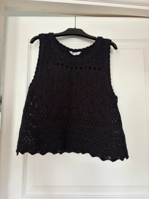 Svart virkad ärmlös topp - Svart virkad ärmlös topp. Toppen är tunt virkad och är hålig vilket gör den genomskinlig. Storlek S, Cubus.