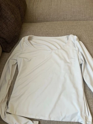 Vit långärmad topp med rund hals - En stilren vit långärmad topp med rundad halsringning. Perfekt att matcha med jeans eller kjol för en clean look. Tunt och mjukt material som känns skönt mot huden. Pris går att diskutera!💕 använd fåtal tillfällen 