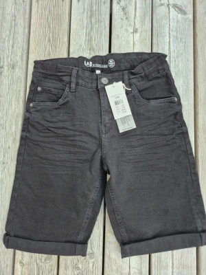 Nya Svarta denimshorts från LAB Industries, strl 164 - Hel nya svarta denimshorts från LAB Industries med fem fickor, uppvikta benslut och klassisk jeanslook. 