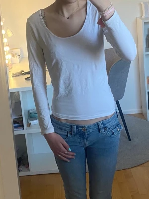 Långärmad vit topp med rund urringning🤍 - En enkel och stilren vit långärmad topp med rundad urringning. Perfekt att matcha med jeans eller kjol för en clean look. Materialet känns mjukt och bekvämt, troligen bomull. Passformen är normal och toppen är helt utan mönster eller detaljer. Använd typ 2 gånger och har inget slitage på eller tecken på användning ut huvudtaget. Toppen är i storlek M men passar också mig som har storlek S. Kontakta mig om ni vill ha fler bilder på eller undrar över något💗 