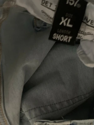 Ljusblå flare jeans från 157 - Säljer ett par ljusblå jeans från 157 i modellen Snake Flare. Jeansen har utsvängda ben och är i längden short, vilket passar perfekt för dig som vill ha ett par trendiga och bekväma jeans med retrovibbar. Klassisk denimlook med snygga sömmar. Passar som M L Xl 