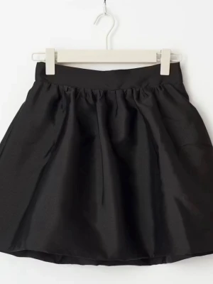 Svart kortkjol med volym - En svart kortkjol med markerad midja och lätt utställd form som ger volym. Kjolen har en enkel och stilren design utan synliga detaljer och passar perfekt till många olika looks.