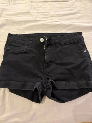Svarta denimshorts med uppvik - Svarta shorts med uppvikta kanter vid låren. Dem är använda mycket men det är inget som märks på dem