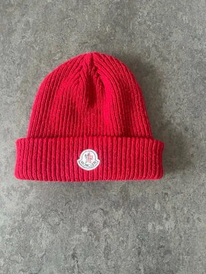 Röd Moncler mössa i ribbstickad ull - Säljer min mössa då jag ej använder den längre.