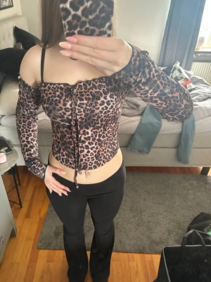 Leopardmönstrad offshoulder topp - Säljer en leopardmönstrad offshoulder topp med långa ärmar och snörning framtill. Toppen är croppad och har en figurnära passform som framhäver midjan❤️