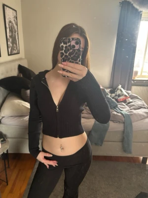 Svart stickad hoodie med dragkedja - Snygg svart stickad hoodie med dragkedja framtill och långa ärmar. Hoodien har ribbad struktur och en huva baktill. Vet tyvärr inte vart den är ifrån men den köptes som ett sett❤️