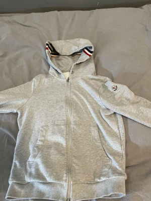 Moncler zip - Säljer nu min fina Moncler zip i fin grå färg då ja inte använder den längre,tröjan är i extremt bra skick och passar perfekt nu till våren/sommaren. Priset är inte hugget i sten och kan diskuteras vid affär. Fråga vid minsta lilla fundering!!