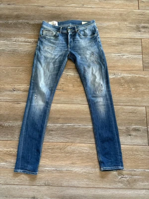Dondup George Skinny Jeans - Snygga dondup jeans i blå denim med slitningar och schysst tvätt. Modellen är George skinny och storlek 31/32. Riktigt schyssta byxor i bra skick. Köptes på NK för nått år sedan. Hör av dig för fler bilder eller mått 🙌