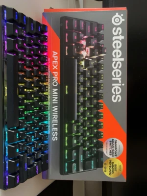 SteelSeries Apex Pro Mini Wireless tangentbord - Säljer ett riktigt schyst SteelSeries Apex Pro Mini Wireless .det är ett kompakt mekaniskt tangentbord med RGB-belysning i flera färger. Tangentbordet har svarta tangenter. Perfekt för gaming och trådlös användning, med justerbara switches och snygg design. Säljer för att jag inte använder det längre. Skick mycket bra hör av er vid frågor. Priset kan diskuteras 