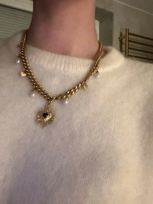 Guldigt wos halsband - Säljer det populära wos halsbandet  i guldfärgad metall med klassisk kedjedesign. Perfekt för att lyfta vilken outfit som helst och ger en trendig touch. 