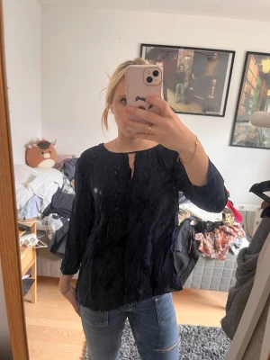 Svart blus med trekvartsärm - Säljer en mörkblå blus med trekvartsärm och rund halsringning med liten öppning framtill. Helt ny, med lapp kvar 