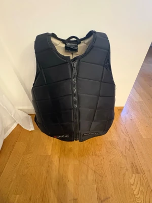 Racesafe säkerhetsväst  - Säljer en svart säkerhetsväst/ridväst från racesafe! Nyare modell som är justerbar vid sidorna. Storlek Kids Large, motsvarar xxs eller mindre xs. Passar mig perfekt som är 162💕☺️ Pris kan diskuteras vid snabb affär. Nypris 3350kr❣️
