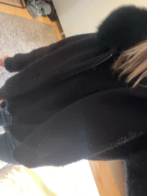 Svart cardigan jacka med päls ( Alessa) - En tjock stickad tröja som är perfekt till våren och hösten. Man kan ta av pälsen på luvan och sätta dit igen. Den kostar original 1800 men säljer för 680kr. Den är lite nopprig på armarna. Har inte testat få bort dom någon gång men de går såklart att lösa nog. Skicka om du vill ha mer bilder på jackan! Den är ifrån Alessa. Pris kan diskuteras 