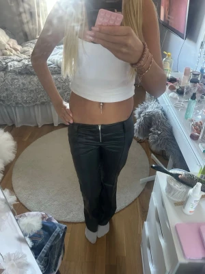 Svarta skinnbyxor med låg midja  - Lågmidjade skinnbyxor från Gina. Använda fåtal gånger. Storlek 152.