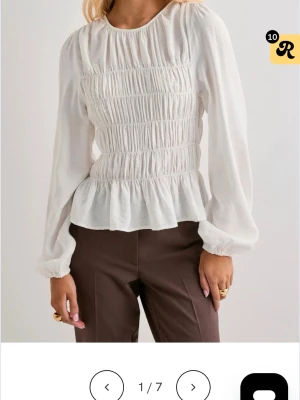 Vit blus från Nelly  - Jättefin trendig vit blus från Nelly! Jättefint skick, säljs pågrund av att den inte passar längre. 