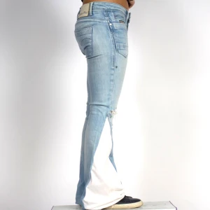 Ljusblå bootcut jeans med vit flare - Passform: midjemåttet: 76 cm och innerbenslängd: 81 cm!🥰 Snygga ljusblå jeans från G-STAR med bootcut passform och vit tyg längs bensidorna. Jeansen har slitna detaljer vid knäna, klassiska fem fickor och låg midja. 