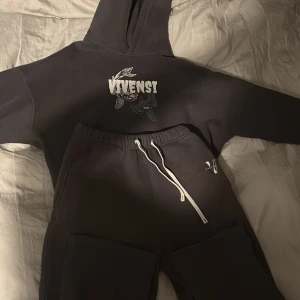 Vivensi dress - Mörk grå  mjukisbyxor med vit dragsko i midjan och liten vit logga på vänster höft. Byxorna har en avslappnad passform och är perfekta för chill eller träning. Matchar med hoodie från samma märke.