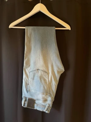 Replay jeans ljusblå  - Tja säljer ett par riktigt schyssta och Snygga ljusblå slim fit jeans från replay med klassisk femficksdesign och diskreta slitningar hål i knät för extra detalj vilket är riktigt snyggt. Jeansen har normal midja och raka ben, perfekta för en avslappnad och trendig look. Modell är replay anbass och storlek 34/34 killen på bilderna är 183 cm lång, skick 10/10, hål i knäna men det är fabrik🤗hör av dig vid mer frågor eller funderingar🙌🏼mvh premium fashion