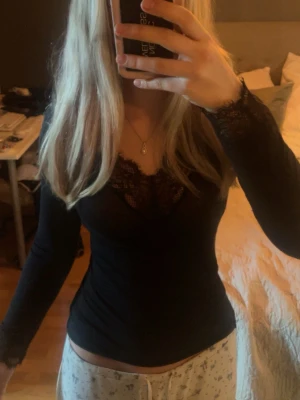 Svart spetsdetaljerad långärmad topp - Virala intimissimi top i svart med spets i nästan nyskick. Endast enstaka noppor som enkelt går att ta bort 