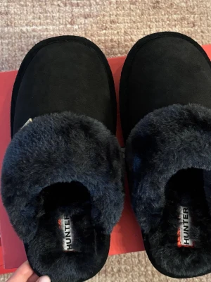 Svarta fluffiga tofflor från Hunter - Svarta tofflor från Hunter i storlek 38