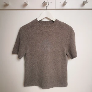 Brun kashmirtröja i 100 % fin kashmir från H&M Premium Quality  - Brun stickad tröja från H&M Premium Quality, med korta ärmar och ribbad halsringning i 100 % fin kashmir. Perfekt för dig som gillar enkel och stilren design. Mjuk och skön kvalitet, passar till både fest och vardag ä. Ny tröja i storlek S. Nypris 1350 kr.  Normal i storleken.