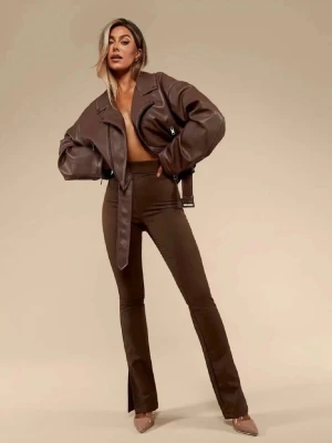 Brun skinnjacka Nelly x Bianca  - Snygg brun skinnjacka från Bianca x Nelly kollektionen med oversized passform och breda slag. Jackan har ett bälte i midjan, dragkedjor på sidorna och långa ärmar. Perfekt för att skapa en cool och trendig look. Knappt använd och går ej att köpa på hemsidan 