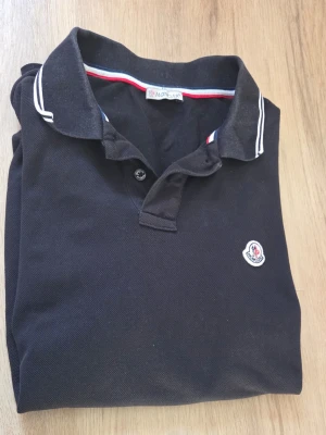 Svart Moncler pikétröja - Väldigt fin pike moncler tröja som jag har använd typ 5 gånger och när den har blivit använd så har den används varsamt. Skriv vid frågor! Priset är inte fast i sten