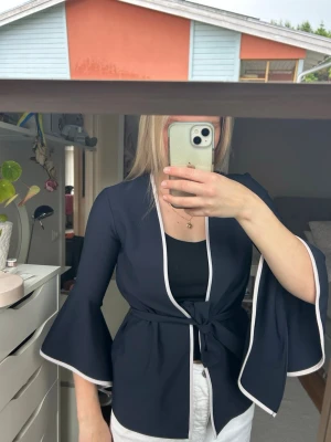 Marinblå kimono-kofta från Zara Basic - Snygg marinblå kimono-inspirerad kofta från Zara Basic med vita kanter och knytband i midjan. Vida trekvartsärmar och materialet är lätt. 