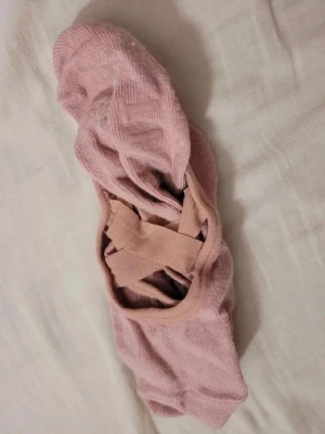 Rosa ballerinastrumpor med resår - Säljer ett par ljusrosa ballerinastrumpor från Crivit. Strumporna har resårband över foten för extra bra passform och halkskydd under sulan. Perfekta till låga skor och tillverkade i mjuk bomullsblandning.