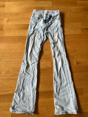 Ljusblå bootcut jeans Gina tricot  - Säljer ett par ljusblå bootcut jeans med klassisk femficksdesign och normal midja. Jeansen har en lätt utsvängd passform nedtill och är tillverkade i denim med en mjuk känsla. Just nu en aning skrynkliga men det är ju superlätt fixat!😄