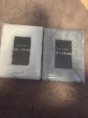 Två fluffiga fotoramar 10x15 cm - Säljer två mjuka och fluffiga fotoramar i storleken 10x15 cm. En ram är vit och den andra är ljusgrå, båda med en mysig textilklädsel som ger en unik känsla till dina bilder. Perfekt för att ge ditt rum en personlig touch 🥰🥰 helt nya och oöppnad