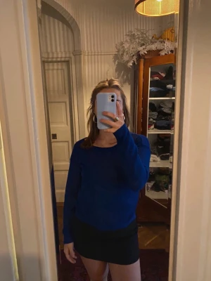 Blå  tröja - En blå stickad tröja med rund halsringning och långa ärmar. Tröjan har en avslappnad passform och en liten bröstficka på vänster sida. Perfekt att matcha med kjol eller jeans för en enkel och snygg look. Tröjan är lite genomskinlig 