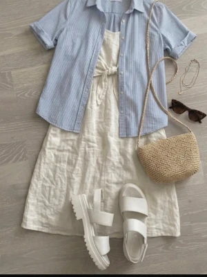 Tiamo Platåsandaler (Vita) - Superfina vita sandaler från Tiamo med en rejäl platå och stadig blockklack. Perfekta både till sommarens fester, studenten eller för att klä upp en vardagslook. Justerbart spänne runt ankeln för bra passform. Tack vare den breda klacken och platån framtill är de bekväma och enkla att gå i! Fint använt skick. 