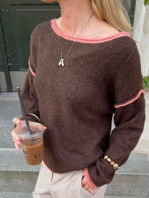 Brun stickad tröja med rosa detaljer - Säljer denna jättecoola design by si tröjan med unika rosa detaljer. Perfekt för lager på lager och enkel att styla till både jeans och kjol vid sommarkvällar eller nu till hösten. Nypris ca 480 kr. Använd av mig men i mycket fint skick. 