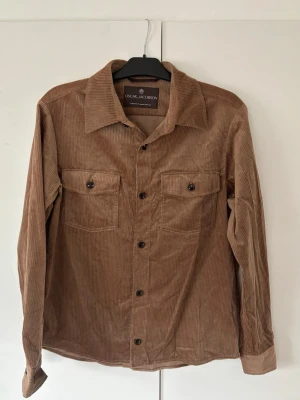 Helt ny Oscar Jacobson overshirt herr M - Superfin ny gyllenbrun Oscar Jacobson overshirt M herr i utmärkt skick och inga som helst defekter. Väldigt eftertraktad elegant glänsande overshirt som är helt perfekt nu till sommaren!