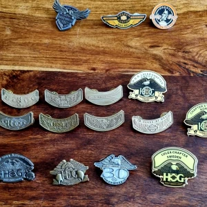 Harley Owners Group (H.O.G.) Pinstat - 15 st (Luleå, Trondheim, 30th Anniversary) - Säljer en fin samling med 15 officiella Harley Owners Group (H.O.G.) pins i ett komplett paket. Perfekt för samlaren eller till västen!  Samlingen innehåller flera eftertraktade och mer sällsynta regionala pins samt jubileumsmärken:Nordiska Chapters: Luleå Chapter Sweden (2 olika örnpins) & Chapter 5 Trondheim Norway.30-Årsjubileum (1983–2013): Officiella "30 Years of H.O.G." jubileumspins.Event-pins: Sweden Custom Bike Meet Sundsvall (2012) & Nordic Harley Days.H.O.G. Rockers: 6st