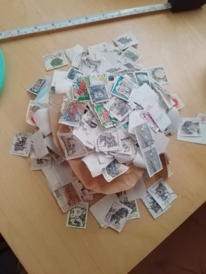 Stor samling frimärken - Säljer en stor blandning av frimärken, många med djur- och naturmotiv. Frimärkena är fastsatta på bitar av kuvert och papper, perfekta för samlare eller pyssel. Flera färger och motiv, varierande storlekar och former.
