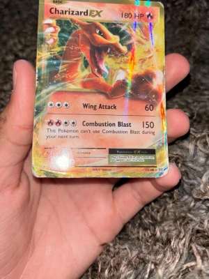Charizard EX Pokémonkort ifrån 2016 - Säljer ett Charizard EX samlarkort  från Pokémon ifrån år 2016 med holografisk yta. Kortet har färgstark design med Charizard i fokus och attacker som Wing Attack och Combustion Blast. Perfekt för dig som gillar att samla eller spela Pokémonkort.