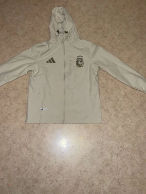 Beige Argentina jacka med huva Adidas - Fett snygg jacka helt ny har aldrig använt den den är perfekt 