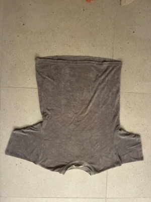 Grå basic t-shirt från H&M - En enkel grå t-shirt från H&M i mjukt material. T-shirten har rund halsringning och korta ärmar, perfekt för en avslappnad stil. Passformen är normal och tyget känns lätt och bekvämt mot huden.