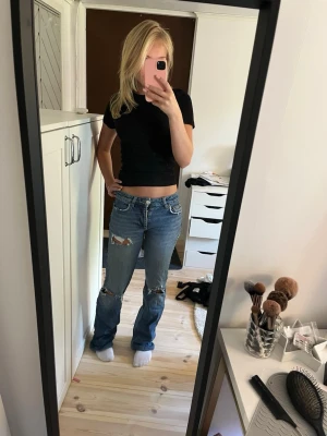 Blå slitna jeans med hål - Lågmidjade jeans med hål i från Gina Tricot men de är omsydda till low waist. Skulle säga att de passar storlek XXS/XS. Att de är nedsydda syns utanpå (se sista bild) men syns inte alls när man har de på sig!💕🥰