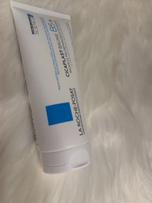 La Roche-Posay Cicaplast Baume B5+ - Multifunktionell vit balm från La Roche-Posay, Cicaplast Baume B5+, i en mjuk plasttub med blå detaljer. Innehåller 100 ml och passar för att lugna och återfukta irriterad hud. Perfekt för dig som vill boosta hudens barriär.