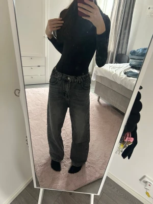 Gråa loose fit jeans - Säljer ett par gråa loose fit jeans med hög midja och raka ben. Jeansen har klassiska fem fickor och elastisk midja baktill för extra komfort. Perfekta för en avslappnad och trendig look.